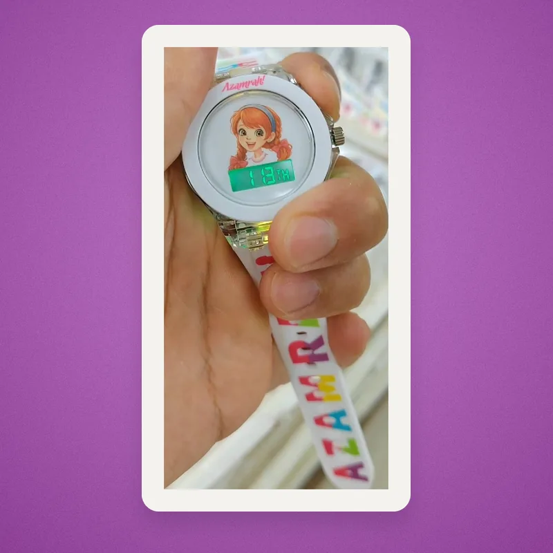 Hand holding a kids' watch with a cartoon girl on the face and 'Azamrah!' on the bezel and strap