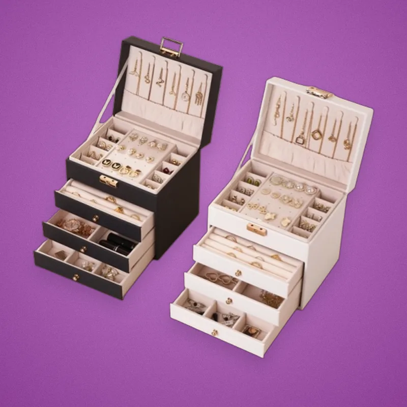 Black and white jewelry boxes with open drawers of rings and necklaces